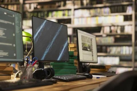 Digital learning screens on library computer monitors and study desk Stock Photos
