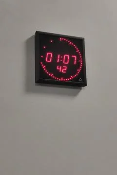 Digital led wall clock with red segmented display showing time and seconds .. Stock Photos