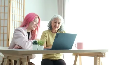 Digital Literacy and Intergenerational Learning. A daughter patiently teaches Stock Footage 306105332