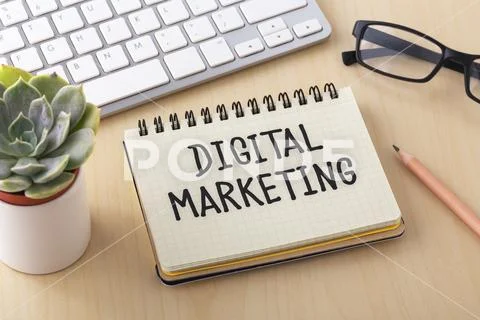 Digital marketing word on notebook with computer keyboard on work desk Stock Photos