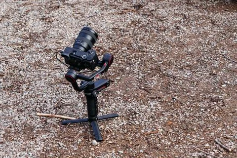 A digital mirrorless camera with a stabilization system is on the ground in a Foto stock
