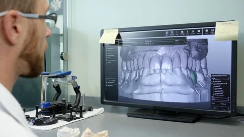 Digital modeling of teeth, male into 3D eyeglasses in front monitor of computer Stock Footage 86830403