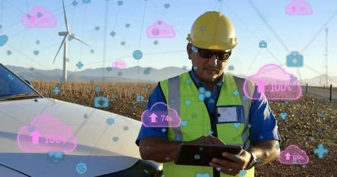 Digital network concept shown with engineer, wind turbines, and pink clouds. 스톡 사진