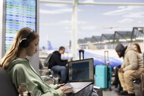 Digital nomad game developer working on laptop in international airport lounge Stock Photos