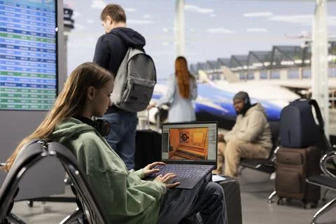 Digital nomad game developer working on laptop in international airport lounge Stock Photos