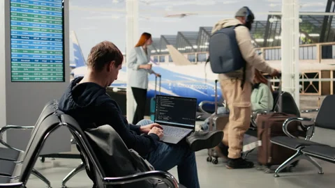 Digital nomad man programming on laptop in international airport 스톡 동영상 333167949