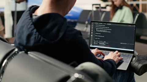 Digital nomad man programming on laptop in international airport 動画素材 333172151