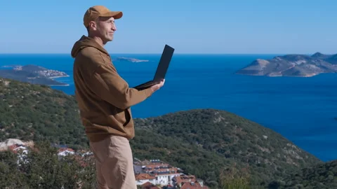 Digital nomad man working on laptop overlooking the sea Stock Footage 326132526