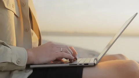 Digital nomad of the millennial generation is working on a laptop on the beach Stock Footage 221417642
