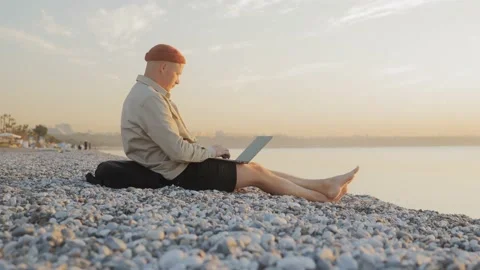 Digital nomad of the millennial generation is working on a laptop on the beach Stock Footage 221418472