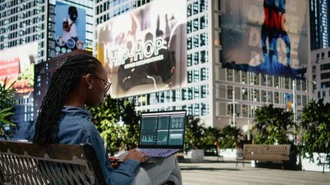 Digital nomad on park bench analyzing business charts and infographics Stock Photos