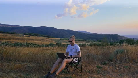 Digital Nomad in Sunglasses Typing on Laptop Outdoors Vídeos de archivo 345717473
