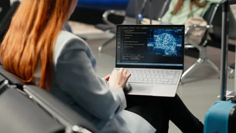 Digital nomad woman coding with AI system in airport terminal Stock Footage 333172150
