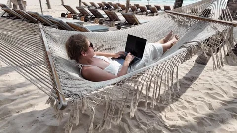 Digital Nomad Woman Working in Beachside Hammock Stock Footage 263337280