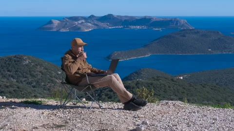 Digital nomad working on laptop overlooking a seascape Stock Footage 334750191