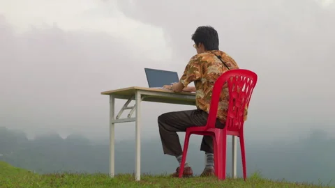 Digital Nomad Works On A Laptop While Sitting At A Table On A Grassy Mountain Stock Footage 344059193