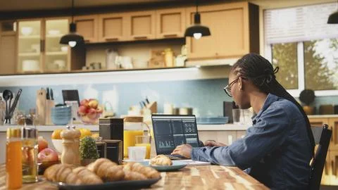 Digital nomad writing research data from charts, laptop displaying analytics Stock Photos