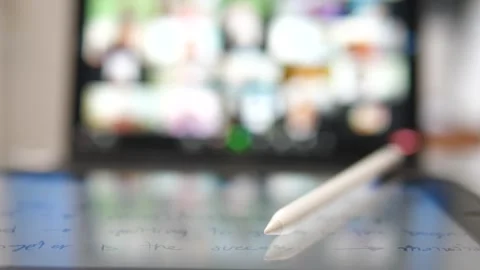 Digital Pen on Tablet with Blurred Video Conference Screen Video stock 309978924