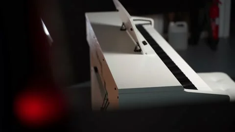 Digital piano in a dark studio. view through the shelves Stock Footage 156937484