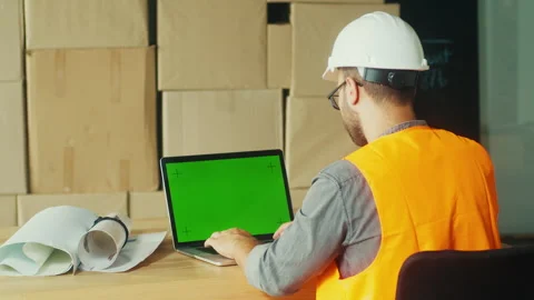 Digital Project Management: Engineer Monitors Construction Progress Using Laptop Stock Footage 311576527