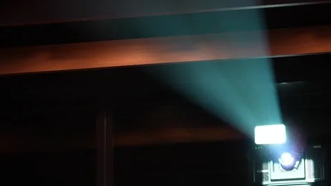 Digital projector emitting bright light beam in a dark room Stock Footage 346359130