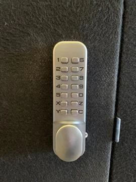 Digital Push Button Code Lock, silver lock attached to a Black fabric door Stock Photos