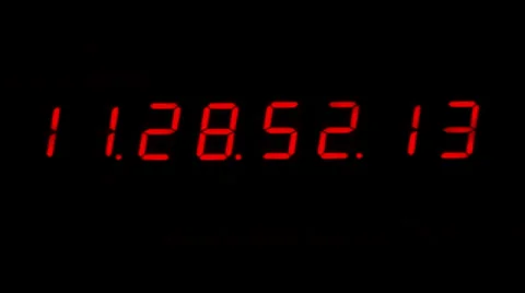 A digital red clock isolated on a black background counting the time Stock Footage 36283589