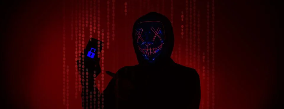 Digital security Concept. Anonymous hacker with mask holding smartphone hacke Stock Photos