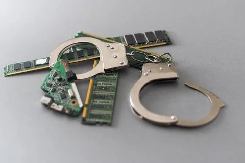 Digital security concept: handcuffs on the background of a computer chip Stock Photos