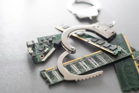 Digital security concept: handcuffs on the background of a computer chip Stock Photos