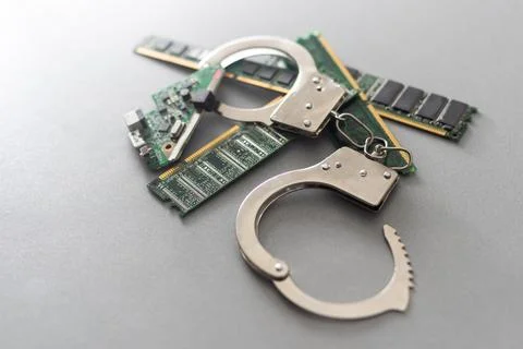 Digital security concept: handcuffs on the background of a computer chip Stock Photos