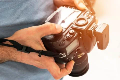 Digital single lens reflex camera in male hands. Photographer shooting hands Stock Photos