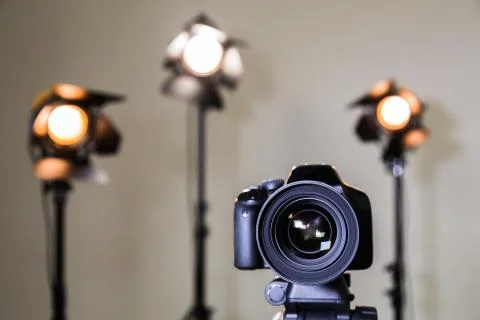 Digital SLR camera and three spotlights with Fresnel lenses. Stock Photos