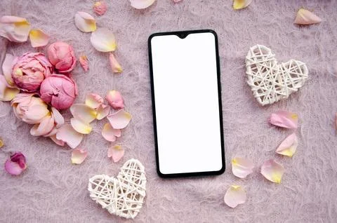 Digital smartphone, blank screen with small petals and white tangled hearts. Stock Photos