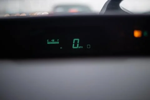 Digital speedometer shining on dashboard under a wet windshield Stock Photos