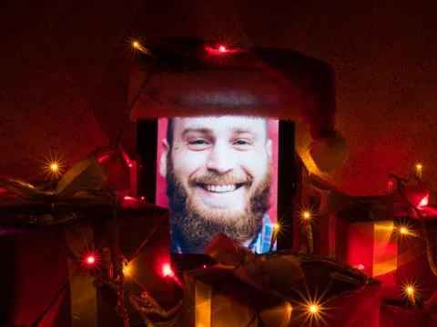 Digital tablet with bearded man on screen and santa cap put on it with christ Foto stock
