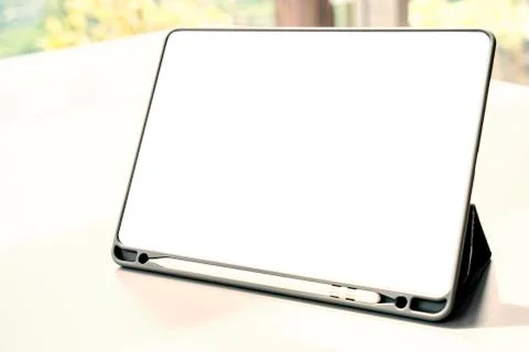 Digital tablet with blank screen on white table, natural warm bright light, b 스톡 사진