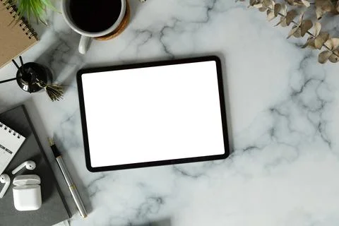 Digital tablet with blank screen, wireless earphone and coffee cup on marble  Foto stock
