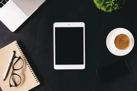 Digital tablet blank screen on work desk top view Stock Photos