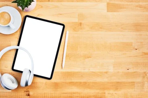 Digital tablet with blank white screen, pen and wireless headphone on wooden  Foto stock