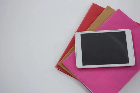 Digital tablet on book stack on white background Foto stock