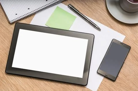 Digital tablet on business table with blank white screen and mobile phone, pa Stock Photos