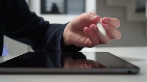 Digital tablet computer with black screen on home table closeup. Guy work on Stock Footage 233767377