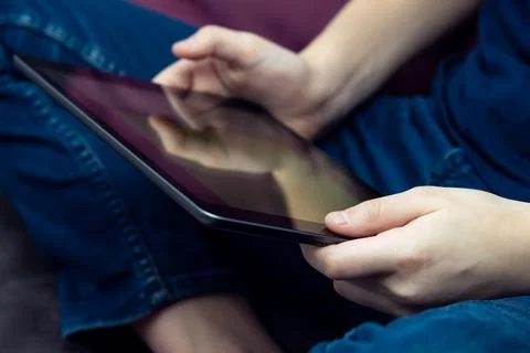 Digital tablet computer in male hands, side view closeup. Guy using multita.. Stock Photos