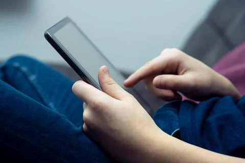 Digital tablet computer in male hands, side view closeup. Young guy working.. Stock Photos