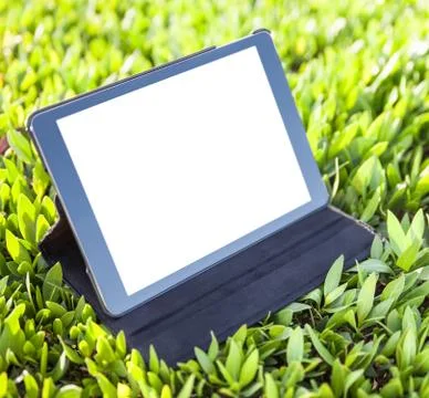 Digital tablet computer over grass background 写真素材
