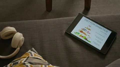 Digital Tablet Displaying Diabetic Diet Guide with Headphones Stock Footage 346286843
