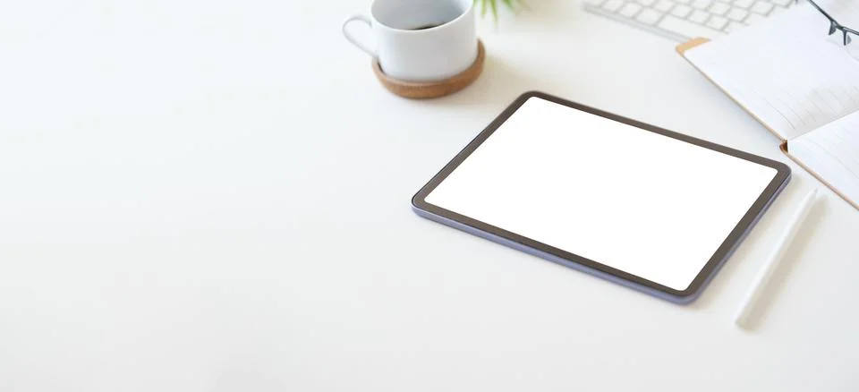 Digital tablet with empty screen on coffee cup and notepad on white office .. Foto stock