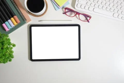 Digital tablet with empty screen on white working desk with office supplies.. Stock Photos