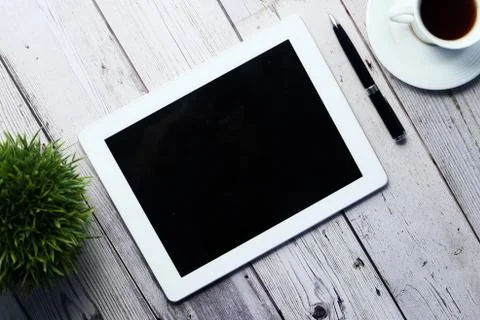 Digital tablet with empty screen on wooden table Stock Photos